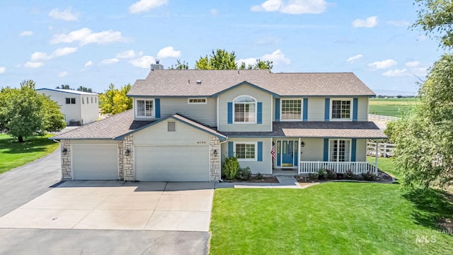 4459 E Deer Flt, Kuna, ID 83634 - view of front of home featuring covered porch, an attached garage, driveway, a front lawn, and a chimney