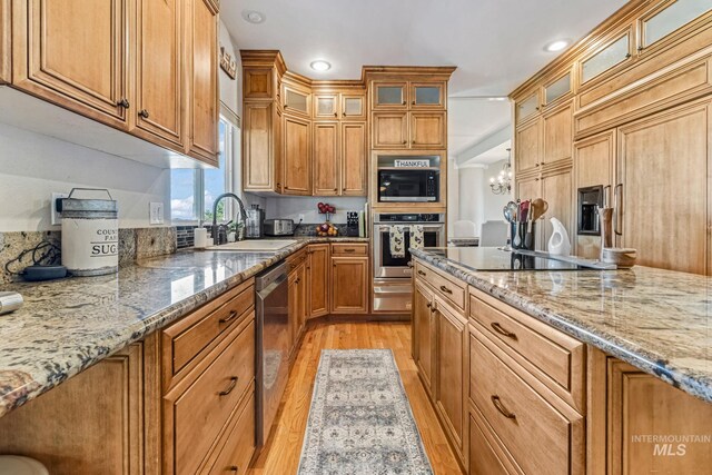 4459 E Deer Flt, Kuna, ID 83634 - kitchen with black appliances, light wood finished floors, light stone countertops, recessed lighting, and a warming drawer