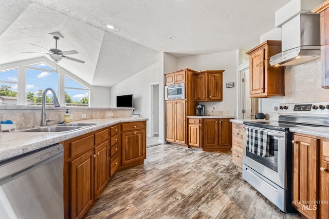 4459 E Deer Flt, Kuna, ID 83634 - kitchen with stainless steel appliances, wall chimney range hood, a textured ceiling, vaulted ceiling, and light countertops