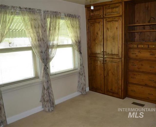 unfurnished bedroom featuring light colored carpet and baseboards