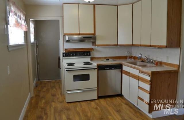 kitchen featuring a sink, light countertops, electric stove, under cabinet range hood, and stainless steel dishwasher