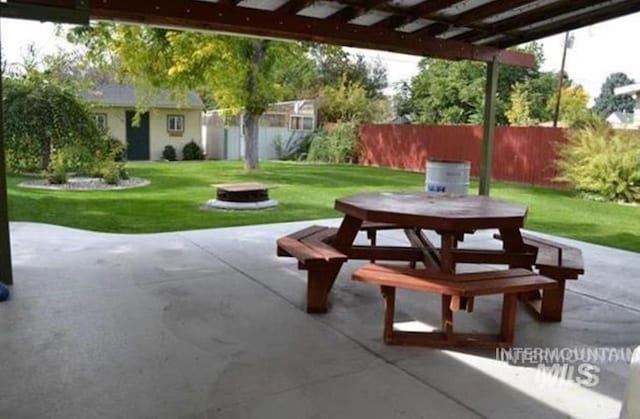 view of patio featuring a fire pit, outdoor dining space, and fence