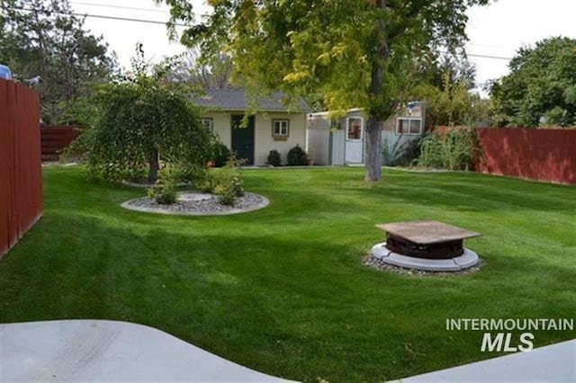 view of yard featuring a fire pit and fence