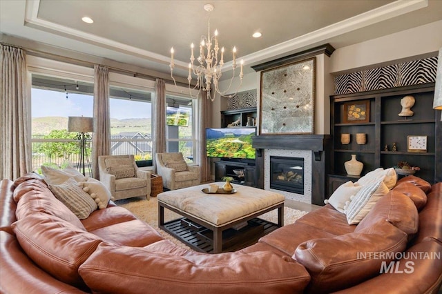 4772 W Barnview Dr, Boise, ID 83614 - living room featuring a chandelier, a glass covered fireplace, crown molding, and a tray ceiling