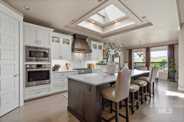 4772 W Barnview Dr, Boise, ID 83614 - kitchen with stainless steel appliances, premium range hood, a raised ceiling, tasteful backsplash, and light countertops