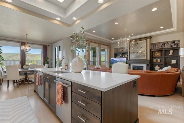 4772 W Barnview Dr, Boise, ID 83614 - kitchen featuring a chandelier, a tray ceiling, stainless steel dishwasher, a sink, and healthy amount of natural light