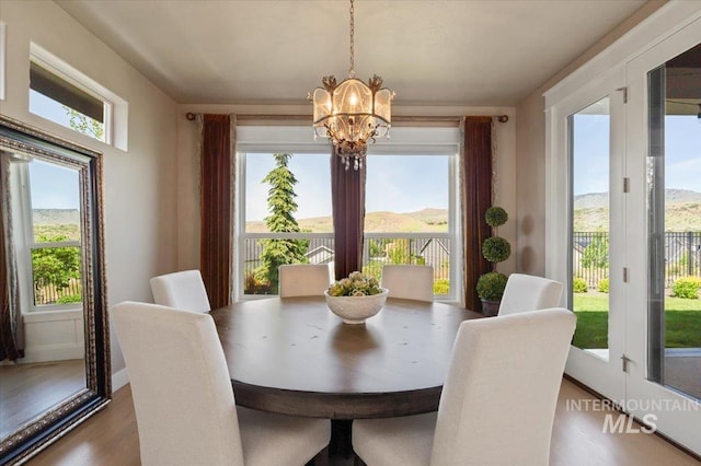 4772 W Barnview Dr, Boise, ID 83614 - dining space with a chandelier, healthy amount of natural light, wood finished floors, and baseboards