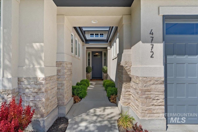 4772 W Barnview Dr, Boise, ID 83614 - view of exterior entry with stone siding, stucco siding, and a garage