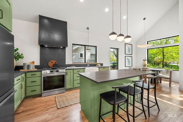 1435 N Garden, Boise, ID 83706 - kitchen with green cabinetry, appliances with stainless steel finishes, extractor fan, a breakfast bar area, and light wood-style flooring