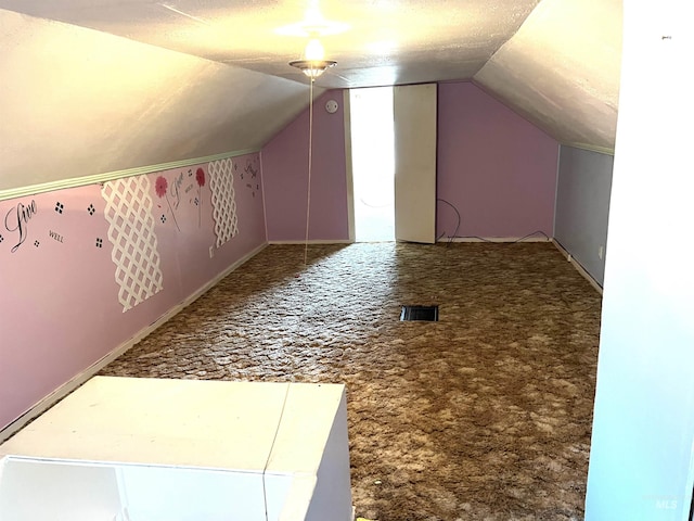 additional living space featuring carpet flooring, a textured ceiling, and vaulted ceiling