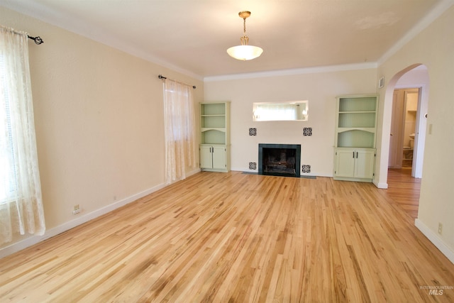 unfurnished living room featuring light hardwood / wood-style floors and crown molding