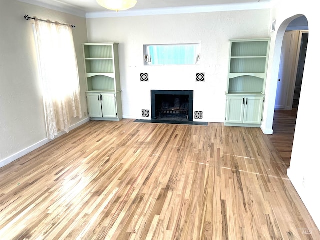 unfurnished living room with light hardwood / wood-style floors and ornamental molding