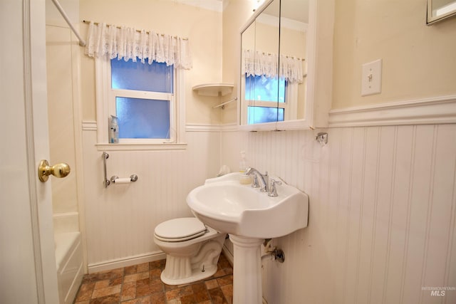 bathroom featuring toilet, wooden walls, and bathtub / shower combination