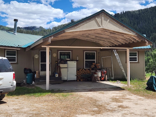 4942 E Baumgartner Rd, Featherville, ID 83647 - back of house featuring a wooded view and metal roof