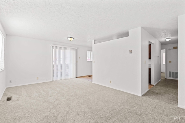 carpeted spare room with a textured ceiling