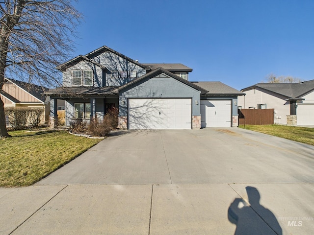 traditional home with driveway, a front yard, an attached garage, and fence