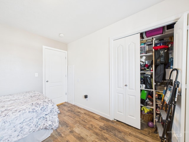 bedroom featuring a closet, baseboards, and wood finished floors