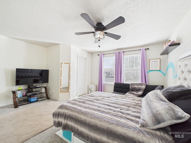 bedroom featuring baseboards, ceiling fan, ensuite bathroom, a textured ceiling, and carpet flooring