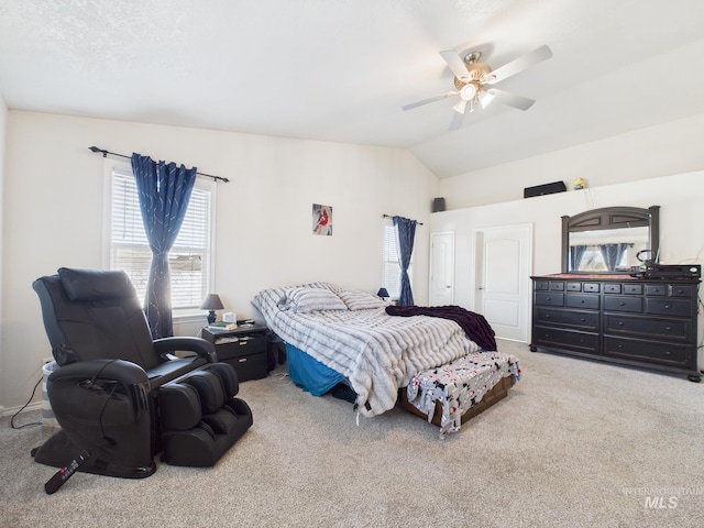 carpeted bedroom with a ceiling fan and vaulted ceiling