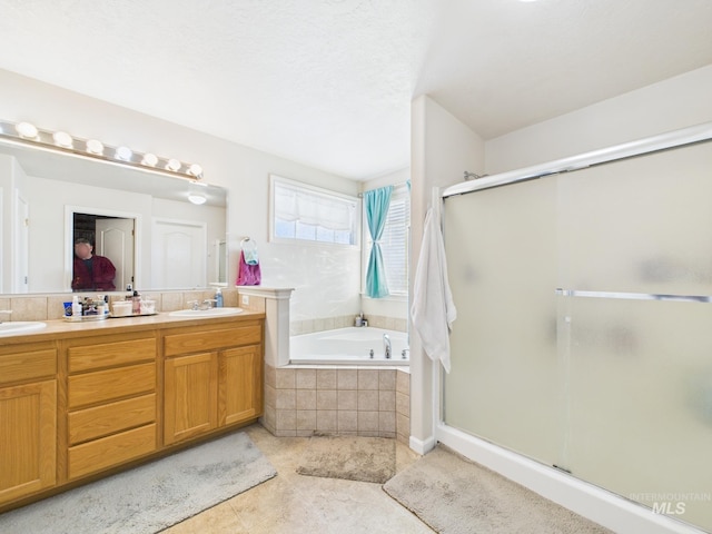 full bath featuring a garden tub, double vanity, a stall shower, and a sink