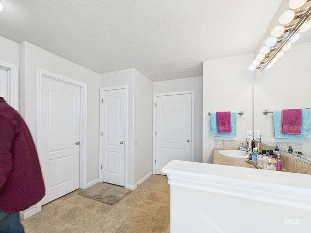 bathroom featuring baseboards and vanity