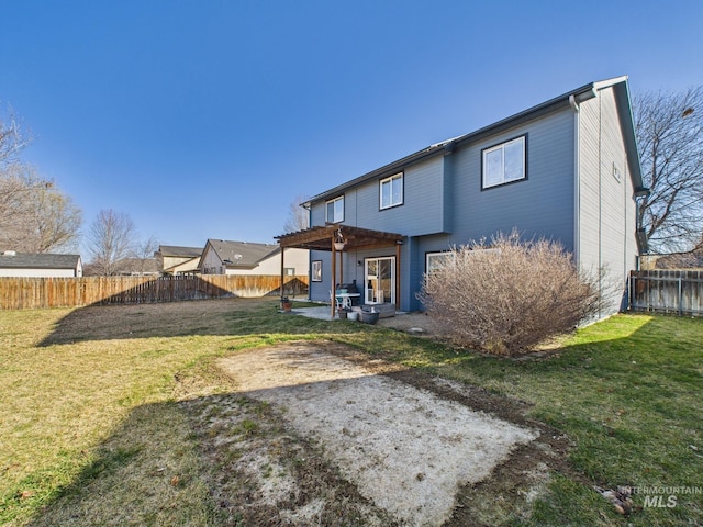 rear view of house with a patio, a yard, and a fenced backyard