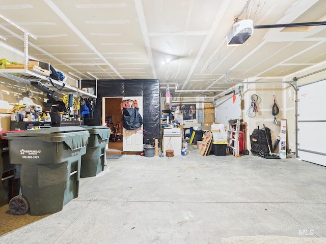 garage featuring electric panel, a workshop area, and a garage door opener