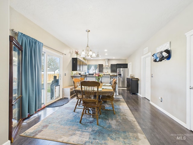 dining area featuring visible vents, baseboards, a chandelier, and dark wood finished floors