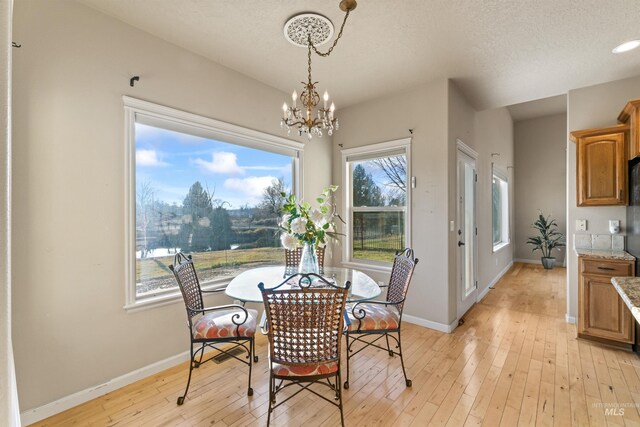 dining area featuring a chandelier, baseboards, and light wood-style floors