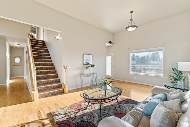 living area with stairs, wood finished floors, and baseboards