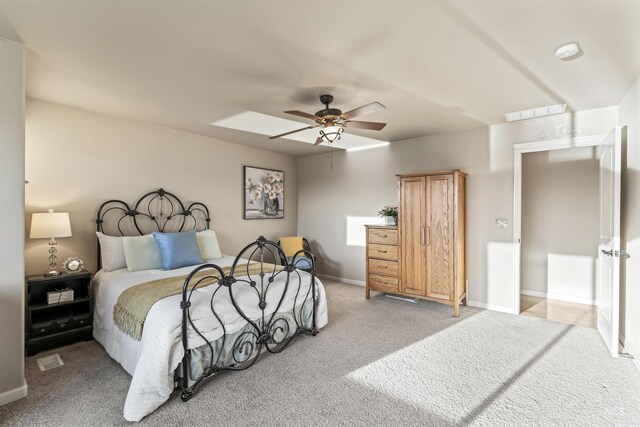 bedroom with light colored carpet, baseboards, and a ceiling fan