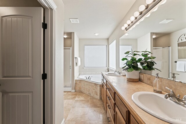 full bath with a stall shower, a garden tub, double vanity, and tile patterned floors
