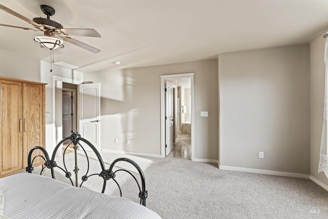 bedroom featuring baseboards, light colored carpet, ceiling fan, and ensuite bathroom