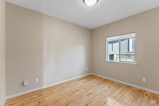 empty room featuring wood finished floors and baseboards
