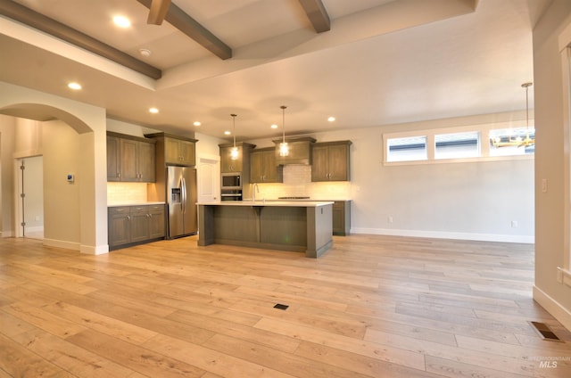 kitchen with pendant lighting, backsplash, stainless steel appliances, and a large island with sink