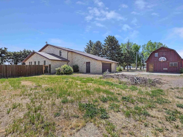 1872 E 1750 S, Gooding, ID 83330 - view of home's exterior featuring a barn, driveway, a garage, an outdoor structure, and brick siding