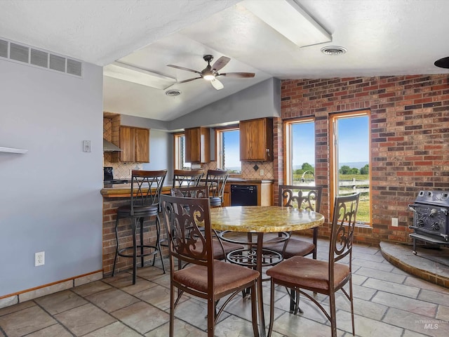 1872 E 1750 S, Gooding, ID 83330 - dining space with a wood stove, ceiling fan, vaulted ceiling, and baseboards