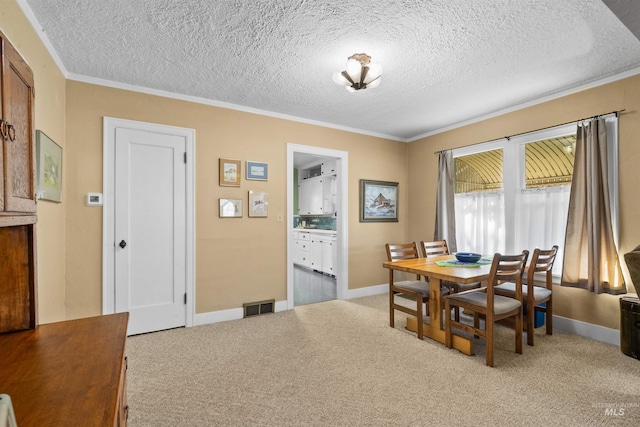 dining room featuring baseboards, carpet, visible vents, and crown molding