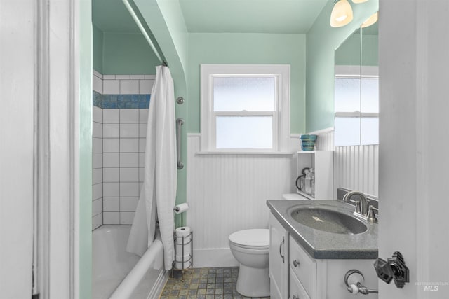 full bathroom with a wainscoted wall, toilet, shower / bath combo, and vanity