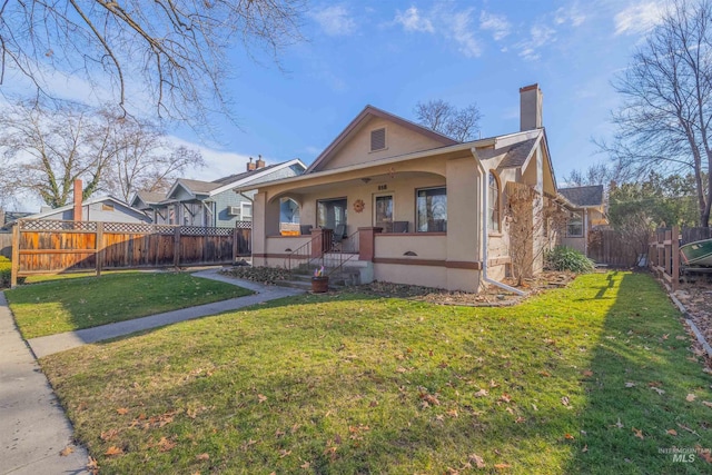 bungalow-style house featuring a porch, fence private yard, stucco siding, a chimney, and a front yard