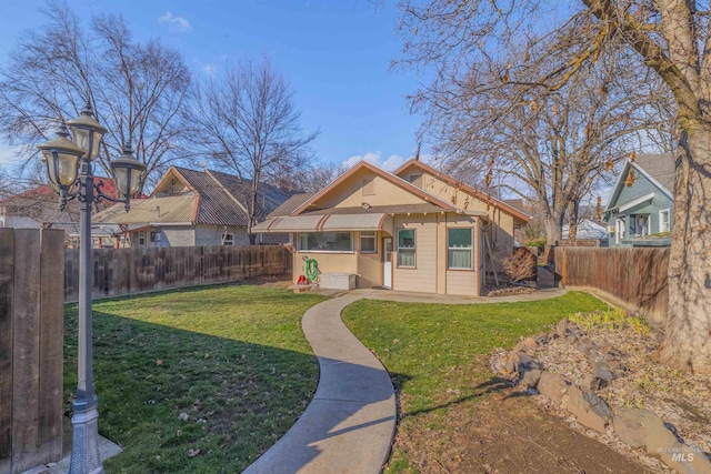 view of front of house with a front yard and a fenced backyard