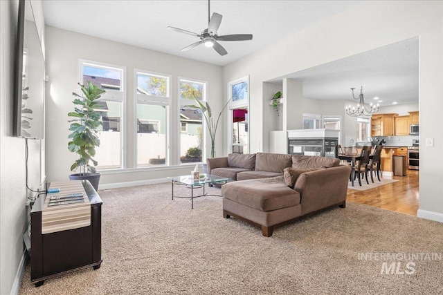605 W Highland Ave, Nampa, ID 83686 - living area with baseboards, light carpet, a wealth of natural light, and ceiling fan with notable chandelier