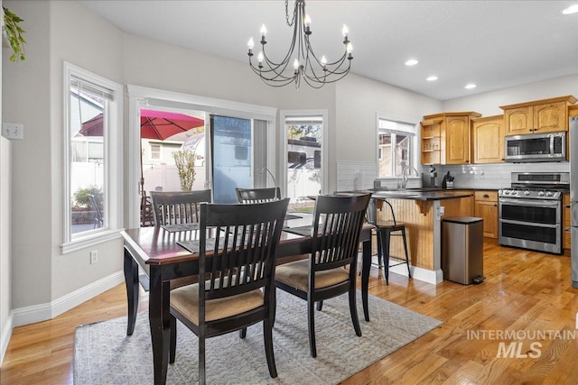 605 W Highland Ave, Nampa, ID 83686 - dining space with baseboards, a notable chandelier, a wealth of natural light, and light wood-style flooring