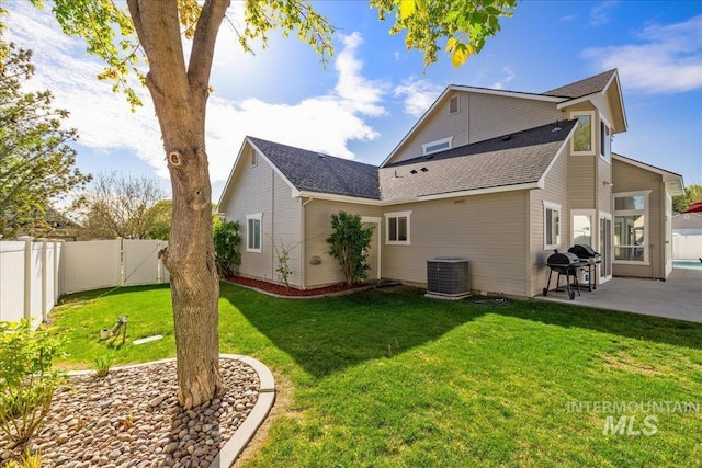 605 W Highland Ave, Nampa, ID 83686 - rear view of property featuring cooling unit, a patio, a fenced backyard, roof with shingles, and a lawn