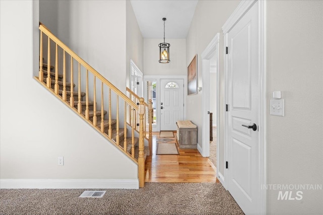 605 W Highland Ave, Nampa, ID 83686 - entrance foyer featuring carpet flooring, stairs, baseboards, a towering ceiling, and visible vents