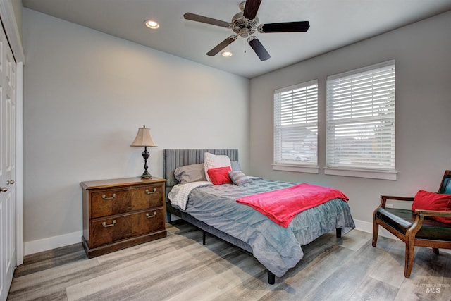 bedroom with ceiling fan, a closet, and light hardwood / wood-style flooring