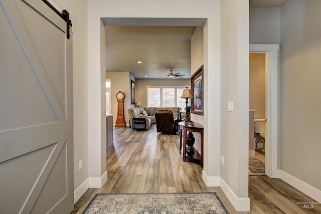 corridor featuring a barn door and hardwood / wood-style flooring