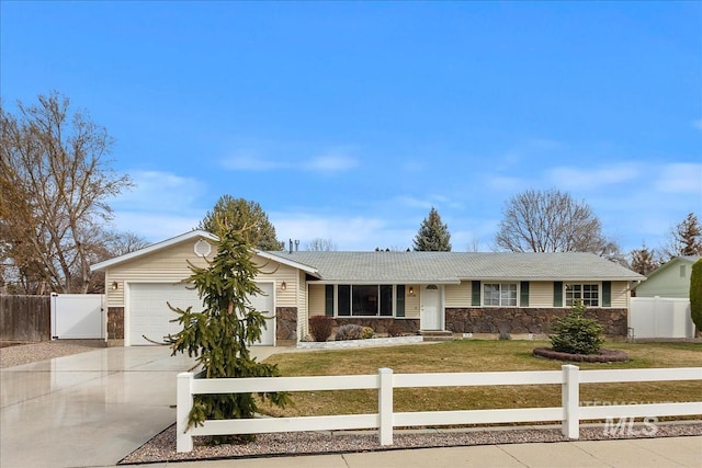 single story home featuring stone siding, a fenced front yard, and concrete driveway