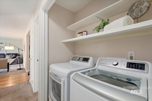 laundry room with light carpet, laundry area, washer and clothes dryer, and light wood finished floors