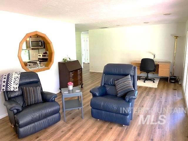 living area with a desk and wood finished floors
